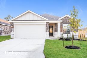 San Antonio house for rent - A house with a white garage door and a small tree in front of it.