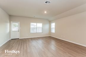 San Antonio house for rent - A spacious room with wooden flooring and a white door.