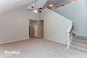 Cypress house for rent - A spacious room with a staircase and a ceiling fan.