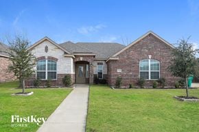 Glenn Heights house for rent - the front of a brick house with green grass and a sidewalk