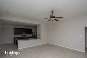 Glenn Heights house for rent - a empty living room with a ceiling fan and a kitchen