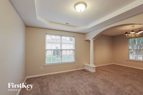 Monroe house for rent - a living room with a carpeted floor and a large window