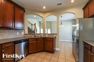 Porter house for rent - A kitchen with wooden cabinets and a stainless steel refrigerator.