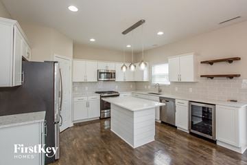 Noblesville house for rent - A kitchen with white cabinets and a wooden floor.