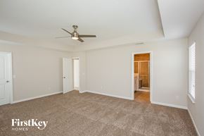 Noblesville house for rent - A spacious room with a carpeted floor and a ceiling fan.