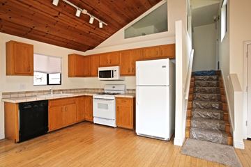 Summerland apartment for rent - A kitchen with wooden cabinets and white appliances.