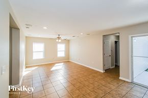 Jacksonville house for rent - A spacious room with tile flooring and a chandelier hanging from the ceiling.