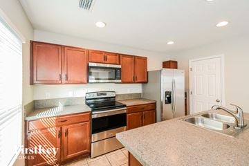 Jacksonville house for rent - A kitchen with wooden cabinets and stainless steel appliances.