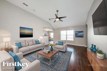 Forney house for rent - A living room with a white couch and a painting on the wall.