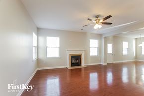Monroe house for rent - an empty living room with a ceiling fan and a fireplace