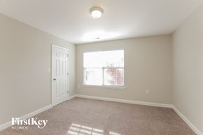 Monroe house for rent - a bedroom with a window and a door and a carpeted floor