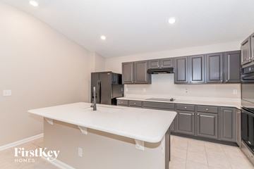 Jacksonville house for rent - a kitchen with gray cabinets and a white counter top