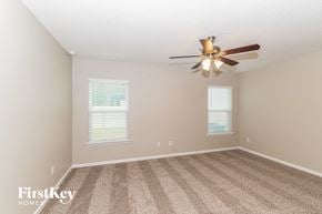 Jacksonville house for rent - a bedroom with carpet and a ceiling fan