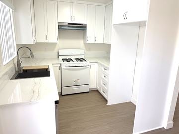 Anaheim apartment for rent - A white kitchen with a stove and a sink.