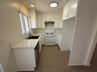 Anaheim apartment for rent - A white kitchen with a dishwasher and a stove top oven.