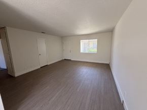 Anaheim apartment for rent - Empty room with wooden floor and white walls.