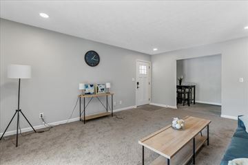College Park apartment for rent - A living room with a wooden table and a clock on the wall.