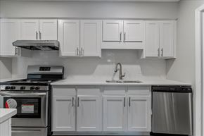 College Park apartment for rent - A modern kitchen with white cabinets and stainless steel appliances.