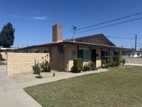 Garden Grove apartment for rent - A house with a brown brick chimney and a green door.