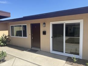Garden Grove apartment for rent - A tan house with a brown door and a glass window.