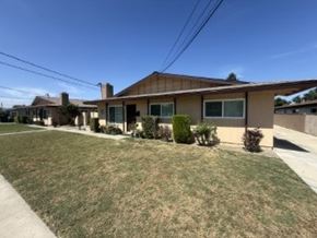 Garden Grove apartment for rent - A house with a brown roof and a green bush in front.