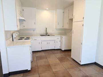 Garden Grove apartment for rent - A kitchen with white cabinets and a tiled floor.