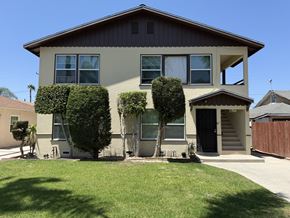 Anaheim apartment for rent - A house with a brown roof and a grey wall with a black door.