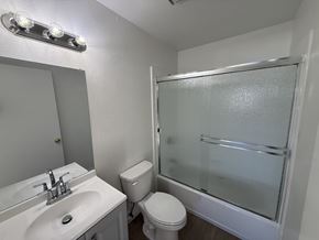 Garden Grove apartment for rent - A white bathroom with a sink, toilet, and shower.