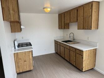 Garden Grove apartment for rent - A kitchen with wooden cabinets and a white countertop.