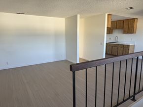 Garden Grove apartment for rent - A room with a wooden floor and a black railing.
