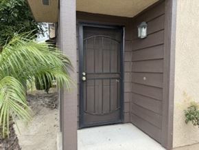 Garden Grove apartment for rent - A brown door is on a house with a plant to the left.