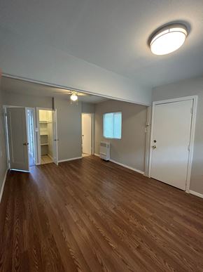 Banning apartment for rent - an empty living room with wood flooring and white walls