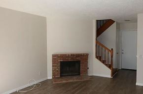 Ontario apartment for rent - a living room with a brick fireplace and a staircase