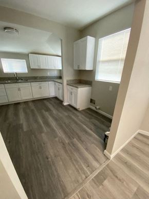 Colton apartment for rent - an empty kitchen with wooden floors and white cabinets