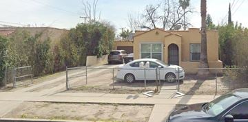 San Bernardino apartment for rent - A white car is parked in front of a yellow house.