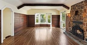 Riverside apartment for rent - a empty living room with a stone fireplace