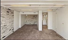 Riverside apartment for rent - an empty room with a brick wall and a carpeted floor