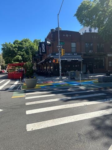 Astoria apartment for rent - A street view with a crosswalk and a building with a sign that says "Kitchen & Bar".