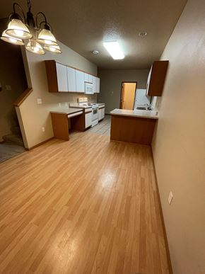 Fargo apartment for rent - an empty kitchen and living room with wood floors