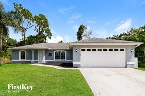 North Port house for rent - a blue house with a lawn and a white garage door