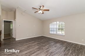 North Port house for rent - an empty living room with a ceiling fan and a window