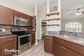 North Port house for rent - a kitchen with stainless steel appliances and wooden cabinets