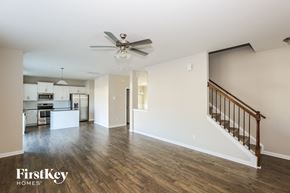 Charlotte house for rent - A spacious living room with a staircase leading to the upper floor.