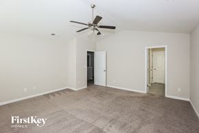 Charlotte house for rent - A spacious room with a carpeted floor and a ceiling fan.