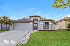 Land O Lakes house for rent - a white house with a driveway and a palm tree