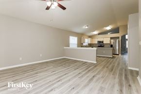 Land O Lakes house for rent - an empty living room and kitchen with wood flooring and a ceiling fan