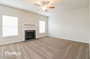 Clayton house for rent - a living room with a fireplace and a ceiling fan