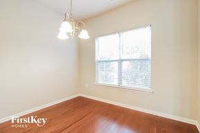 Clayton house for rent - a bedroom with a large window and wood floors