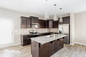 Locust house for rent - a kitchen with dark wood cabinets and a marble counter top