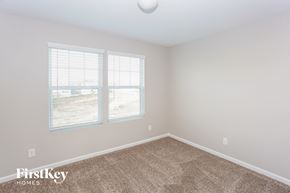 Locust house for rent - a bedroom with a carpeted floor and two windows